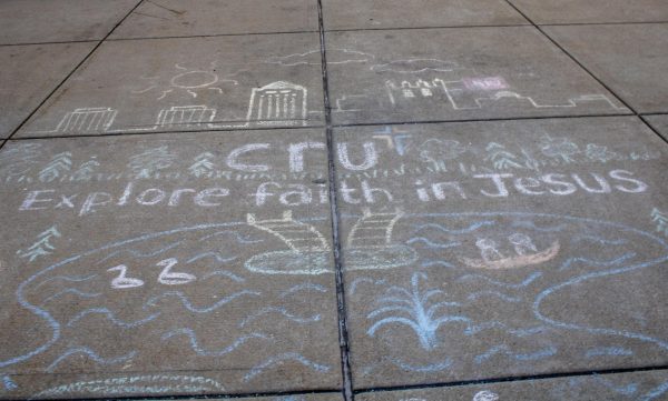 A chalk drawing from the NIU CRU Christian Ministry at MLK Commons spells out “Explore faith in Jesus.” Opinion Columnist Will Thiel identifies as Christian and inspires his politics from religious values. (Tim Dodge | Northern Star)