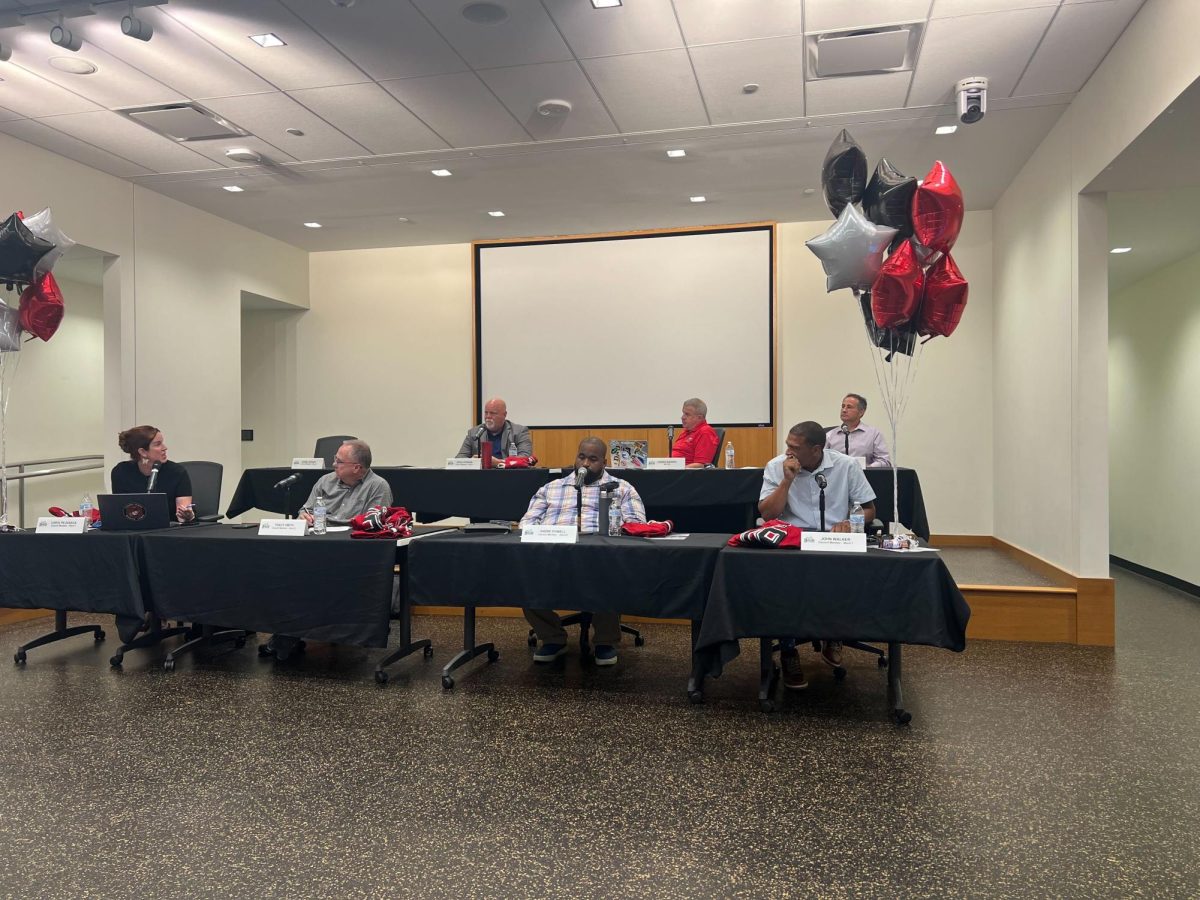 Members of the DeKalb city council talk at Monday's City Council meeting. The city council voted on an ordinance that would allow salons, spas and barbershops to sell alcohol to people 21 or older. (Devin Oommen | Northern Star)