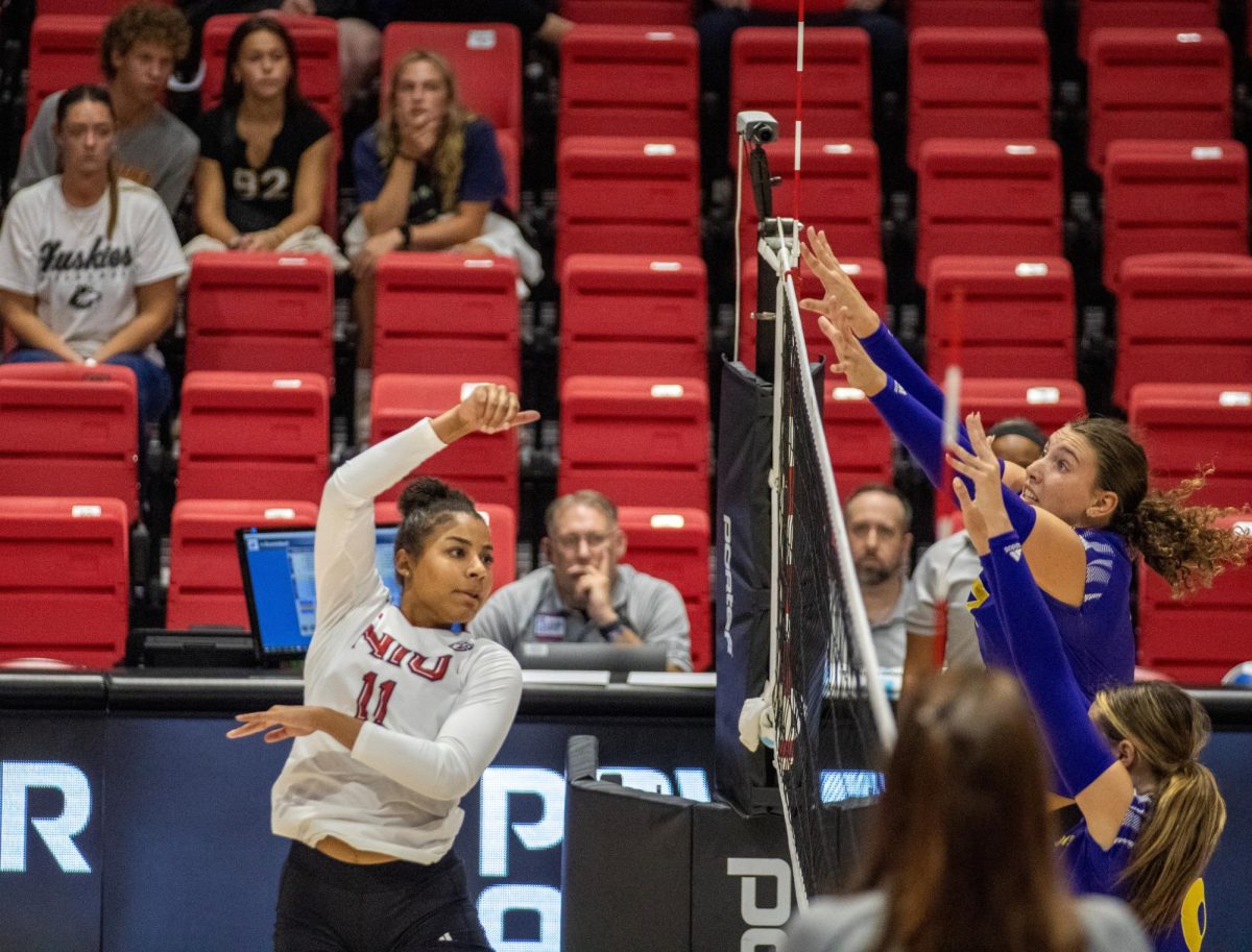 Senior middle blocker Charli Atiemo hits the ball over the net on Aug. 30 against Western Illinois University. Atiemo recorded 33 kills and 7 service aces as NIU volleyball lost both games of a doubleheader on Friday. (Tim Dodge | Northern Star)