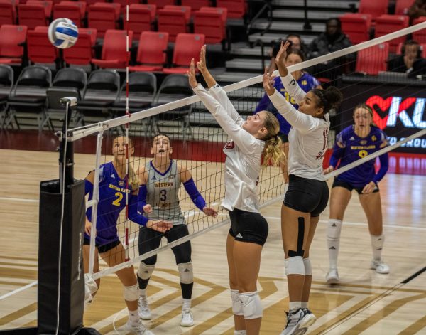 Freshman outside hitter Ava Grevengoed (left) and senior middle blocker Charli Atiemo attempt a block Friday at the Convocation Center. NIU volleyball lost in five sets to the University of Wisconsin-Milwaukee Sunday to fall to 0-2 on the season. (Tim Dodge | Northern Star)