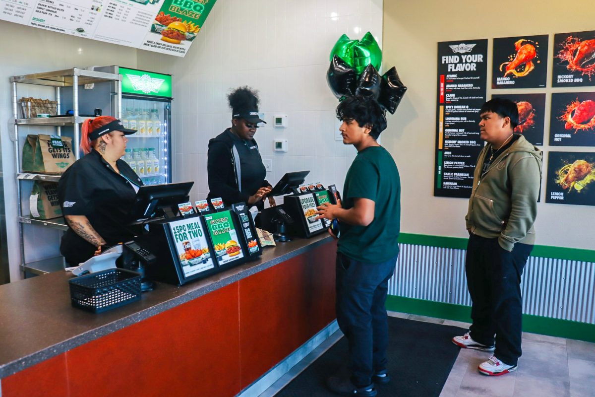 Luis Hernandez, left, an Elgin resident, and Noe Mendez, a DeKalb resident, order wings at the new Wingstop. The new Wingstop opened at 11 a.m. Monday in Sycamore. (Marco Alvarez | Northern Star)