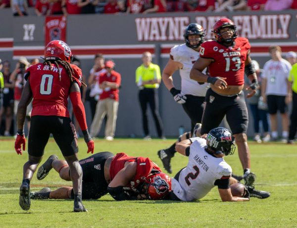 NIU redshirt junior quarterback Ethan Hampton (2) is tackled by North Carolina State University graduate student defensive end Davin Vann (1) after rushing for a 9-yard gain on the final drive of NIU’s 24-17 loss Saturday at Carter-Finley Stadium in Raleigh, North Carolina. Hampton finished the game with nine carries for a loss of 19 yards. (Tim Dodge | Northern Star)