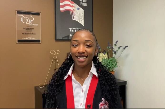 The National Pan-Hellenic Council President Imani Jones stands in front of a bookshelf. The NPHC fraternities and sororities are also referred to as the Divine Nine. (Brynn Krug | Northern Star)