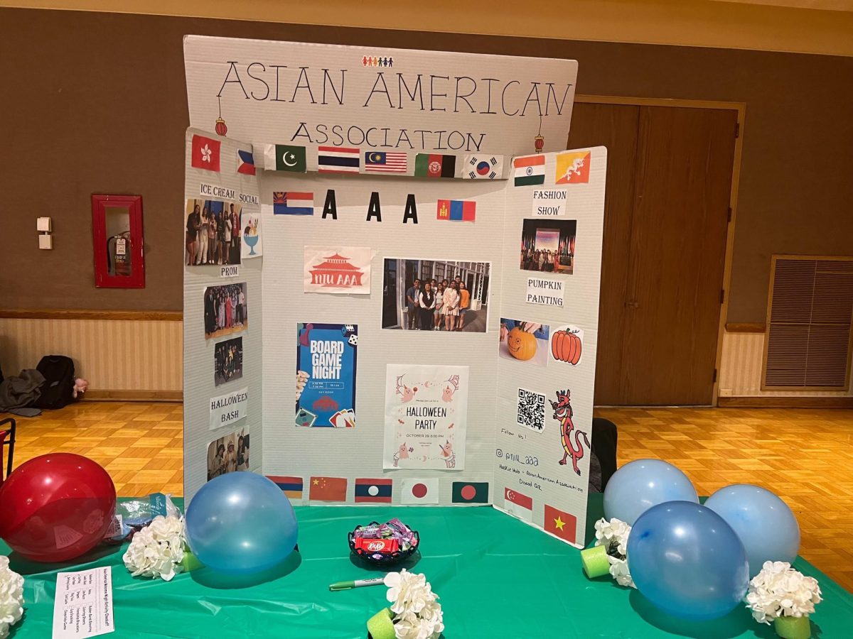 A poster that reads "Asian American Association" sits on a table in the Regency Room of the Holmes Student Center. The Asian American Resource Center hosted its Welcome Night from 5 p.m. to 7:30 p.m. Tuesday. (Gray Edelstein | Northern Star)