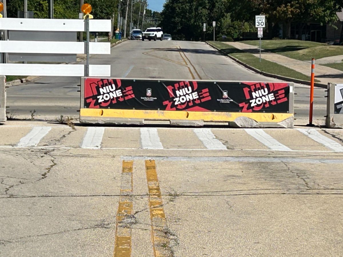 A barricade that reads NIU Zone sits on Normal Road. The roundabout at the intersection of Normal Road and Lucinda Avenue is expected to be completed by August 2025. (Emily Beebe | Northern Star)