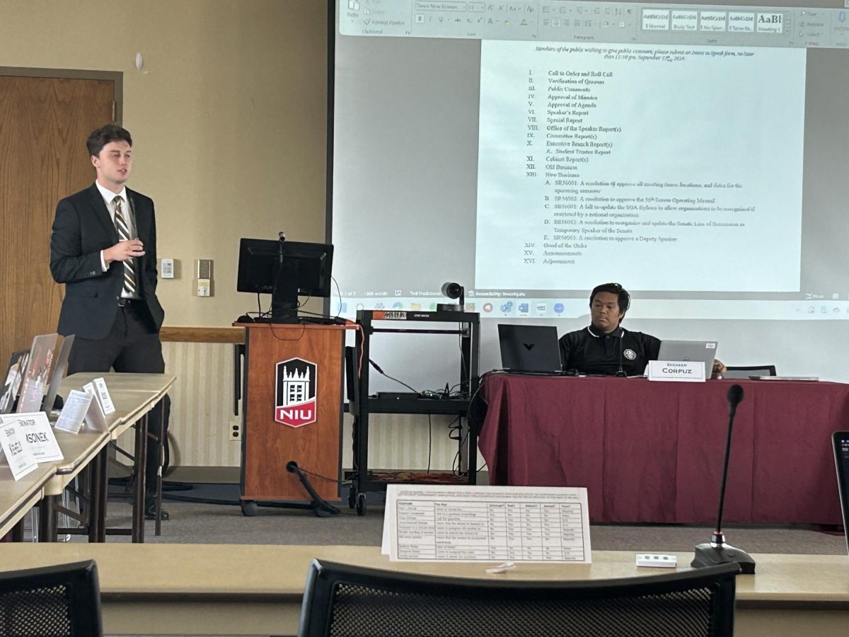 Aidan O’Brien, SGA student trustee, stands by the podium and speaks at Friday’s SGA senate meeting. O’Brien gave an update about NIU’s finances and enrollment numbers. (Emily Beebe | Northern Star)