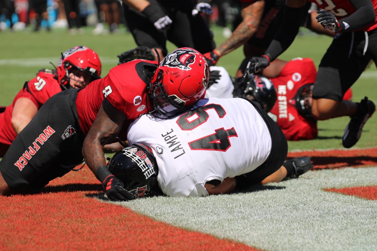 Senior fullback Brock Lampe (49) recovers a fumble in the endzone with North Carolina State University graduate student linebacker Devon Betty fighting for the ball on Saturday in Raleigh, North Carolina. Lampe's touchdown tied the score at 7-7 late in the first quarter. (Tim Dodge | Northern Star)