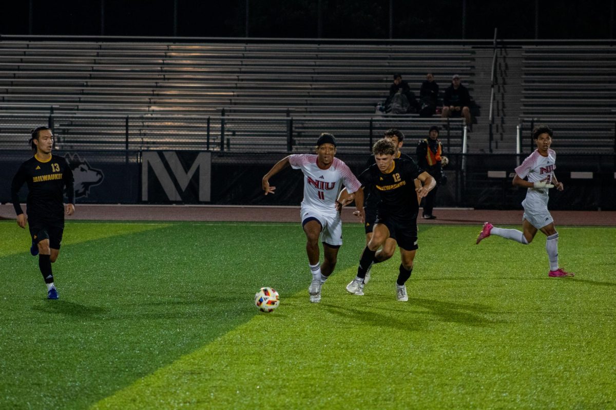 Sophomore forward Sam Divis (11) races University of Wisconsin-Milwaukee freshman defender Ryan Beghauer (12) to the ball near midfield on Tuesday at the NIU Soccer and Track & Field Complex. NIU men's soccer lost 4-2 to the University of Illinois Chicago on Saturday. (Northern Star File Photo)