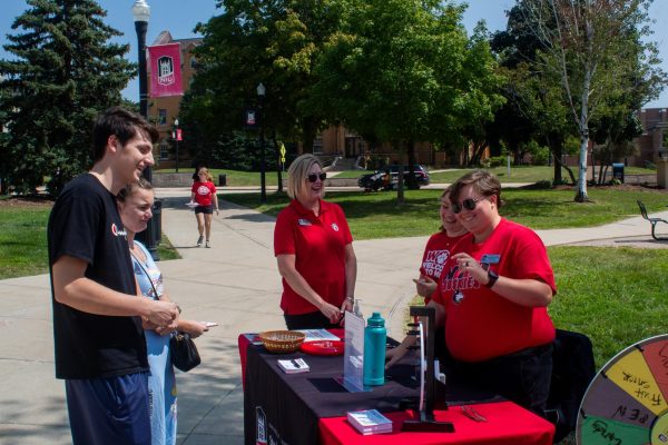 Zach Conro (left), a sophomore finance major, and Shawna Koslovich, a junior nursing major, answer trivia at the Student Financial Services to spin a wheel and win prizes. The questions asked ranged from ‘What days are food trucks on campus’ to ‘When did NIU adopt the fight song.’ (Totus Tuus Keely | Northern Star)
