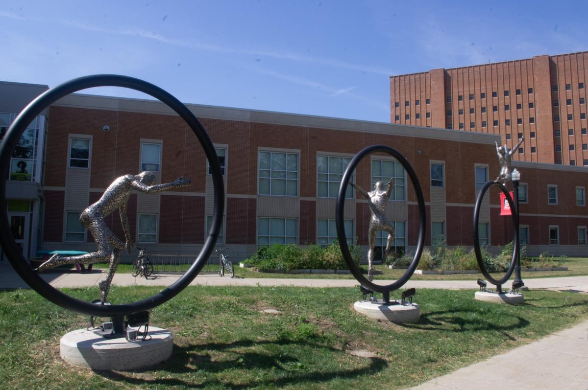 The sculpture "The Tribesmen, The Hero, and The Light" sits outside the Stevens Building on a sunny Friday afternoon. The sculpture was finished in September. (Sam Dion | Northern Star)