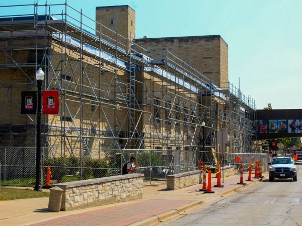 Taanisha Muhammad, a junior biological science major, walks past the scaffolding lining the facade of Swen Parson Hall. Swen Parson Hall is getting all of the flat roofs replaced and the project is expected to be completed by the end of the spring 2025 semester. (Totus Tuus Keely | Northern Star)