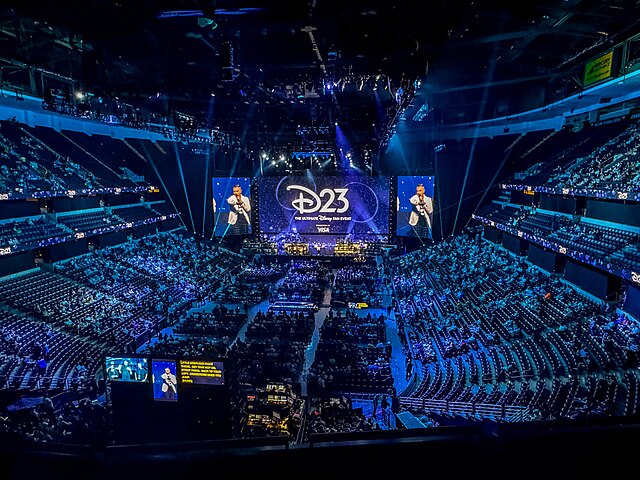 A large screen sits in an arena at the annual D23 expo. During this event, Disney announced multiple upcoming projects including "Frozen 3" and "Moana 2." (courtesy of Wikimedia Commons)