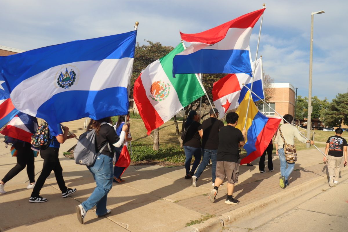 Students wave Latin American flags during the Latino Resource Center’s parade for Latino Heritage Month on Monday. How are you celebrating Latino Heritage Month this year? (Marco Alvarez | Northern Star)