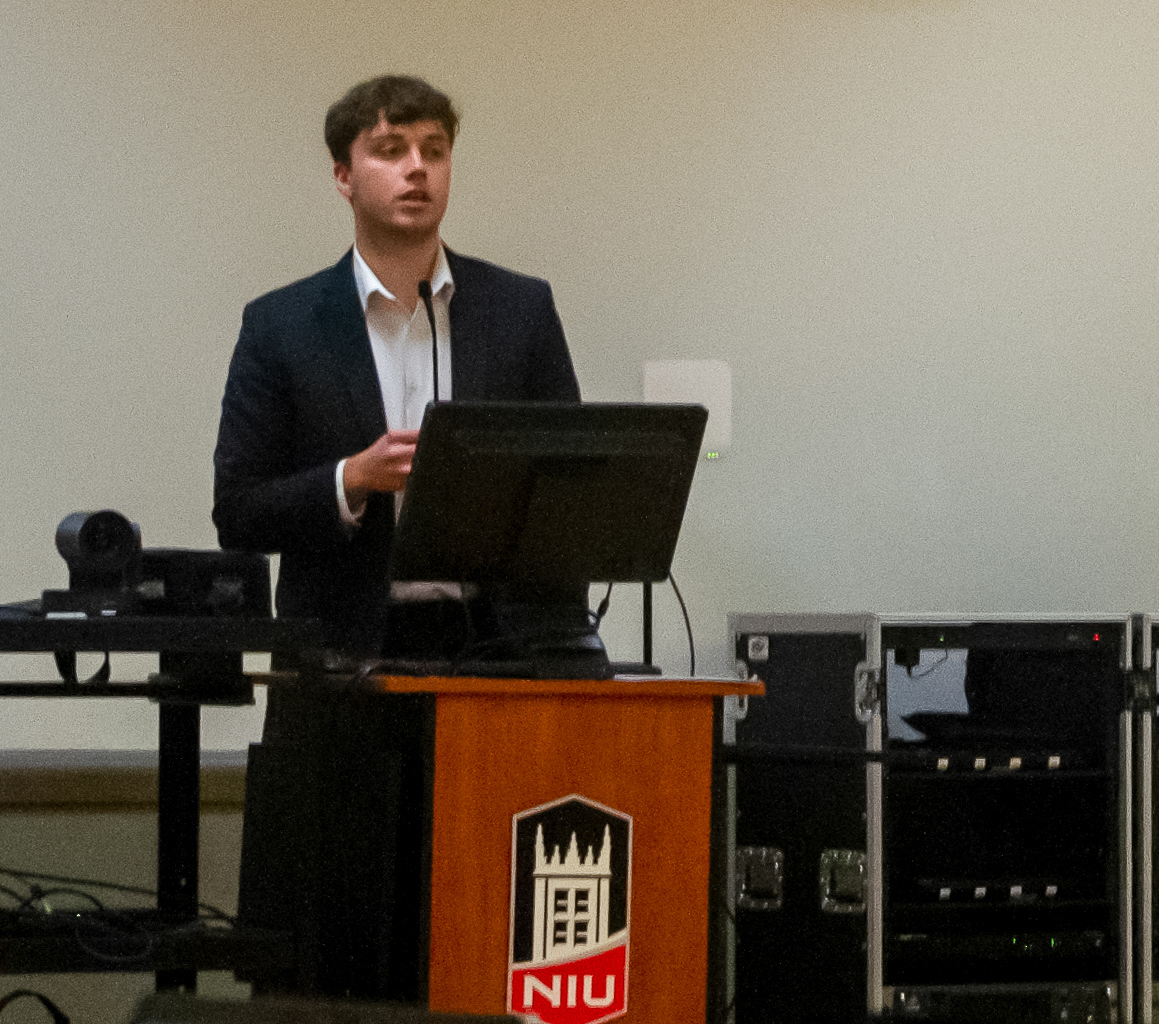 Aidan O'Brien, student trustee for the Student Government Association, stands behind a podium and talks. O'Brien provided an update about the new energy savings agreement the NIU Board of Trustees passed. (Sam Dion | Northern Star)