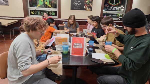 A group of NIU students paint canvases at the Night at Holmes: Homecoming Edition event which occurred Thursday. Night at Holmes was one of the many events that occurred throughout Homecoming Week. (Joseph Ndu | Northern Star)