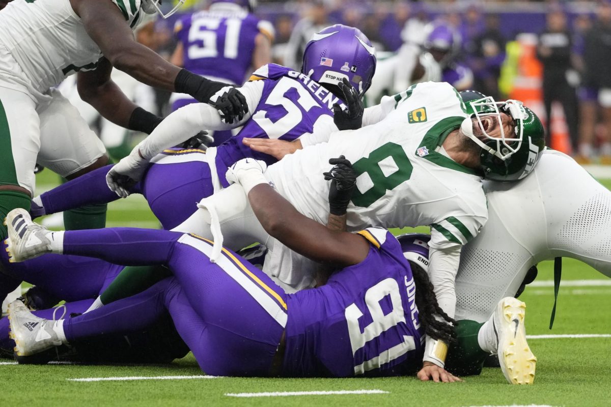 New York Jets quarterback Aaron Rodgers (8) is tackled in a NFL football game against the Minnesota Vikings on Sunday. Assistant Opinion Editor Jackson Shields believes the NFL's prioritization of style over safety traps its athletes in a dangerous lifestyle that mimics the Roman gladiators. (AP Photo/Kirsty Wigglesworth)