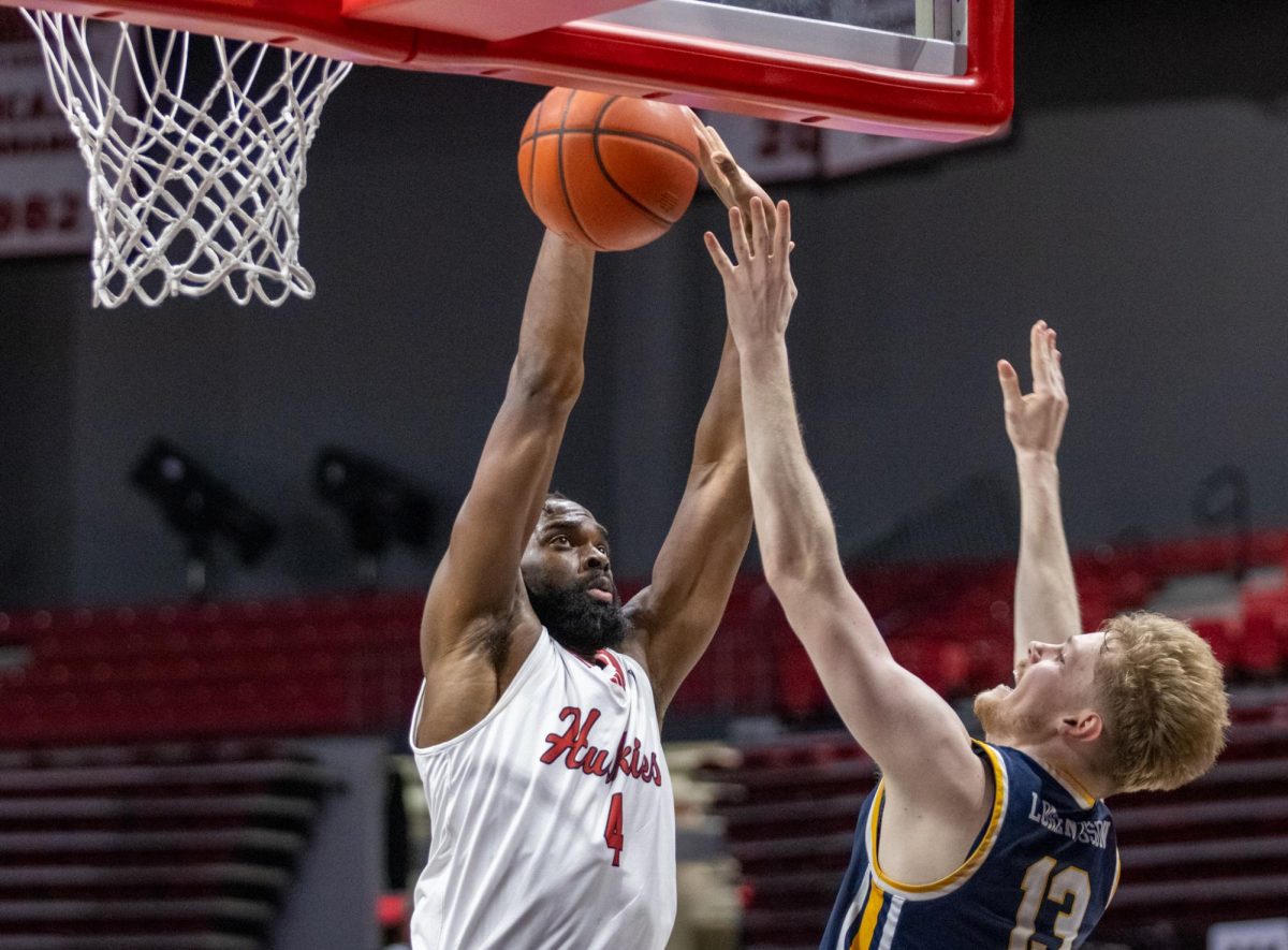 Then-junior forward Oluwasegun Durosinmi (4) leaps to block a shot on Jan. 23 against the University of Toledo Rockets. Durosinmi is one of five returning players for NIU men's basketball in 2024-25. (Northern Star File Photo)