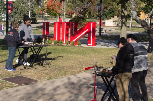 Students from the NIU Percussion Ensemble stand near the Founders Memorial Library and MLK Commons at the “Huskie Sound Garden” event. Gongs, windchimes, rain sticks, finger cymbals and handbells were among the instruments performed. (Sam Dion | Northern Star)