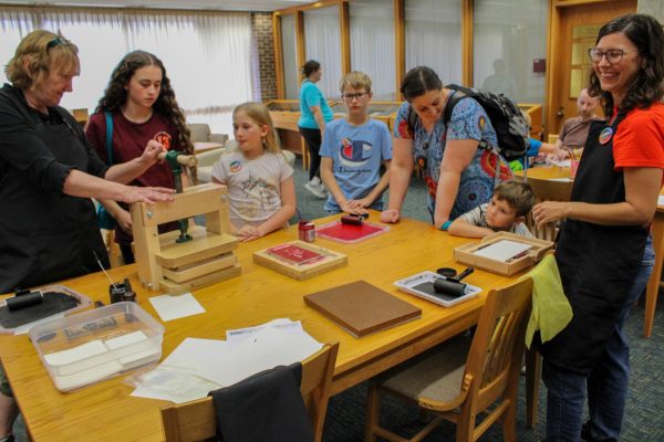 Employees of the Special Collections and Archives Department at NIU help children learn about how printing was done with bright colors and fun shapes. The Special Collections and Archives Department at NIU’s Founders Memorial Library is restoring three printing presses previously used by NIU for a future class called “The History of the Book.” (Ethan Rodriguez | Northern Star)