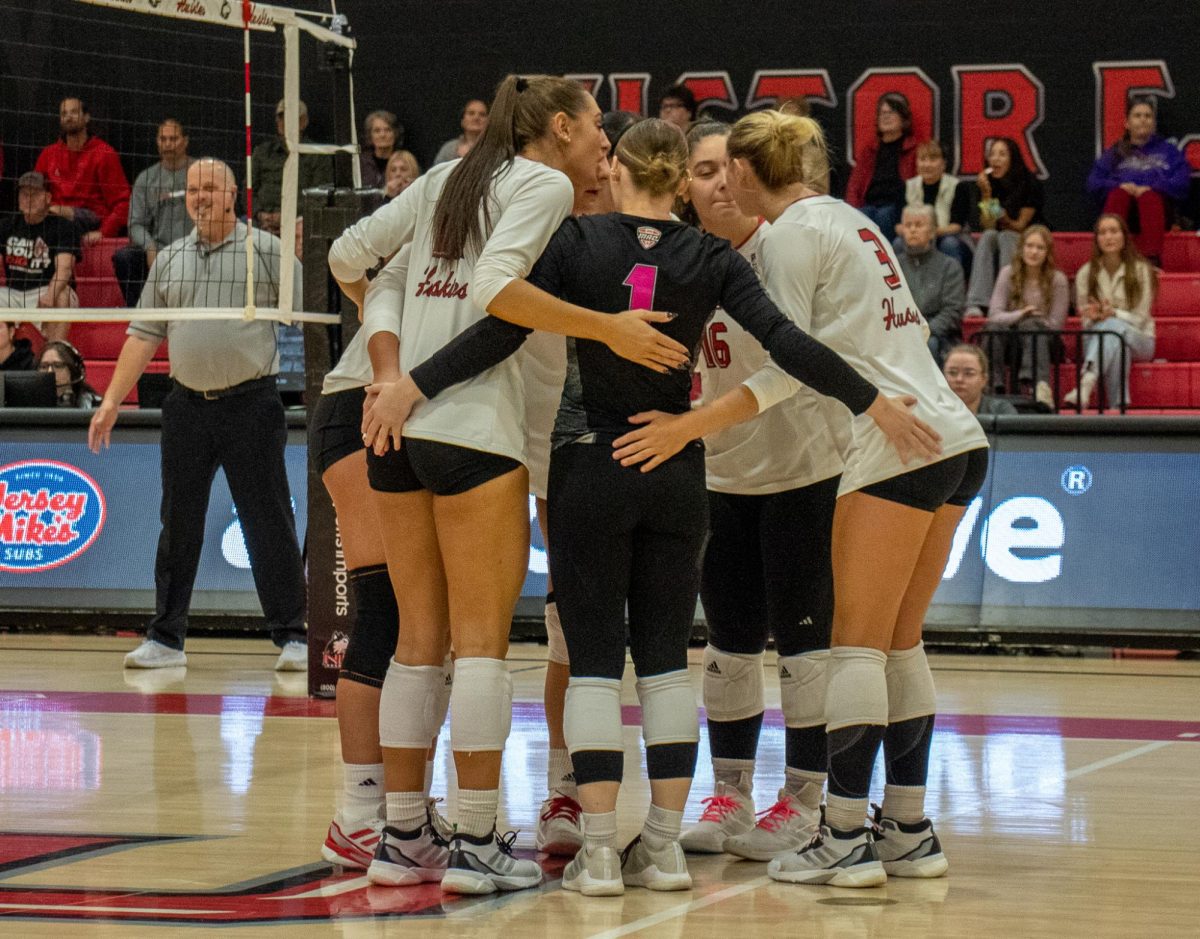 Members of the NIU volleyball team huddle during their match against the Ball State University Cardinals on Saturday in DeKalb. The Huskies fell to the Cardinals in three sets, dropping to an overall record of 3-18. (Marco Alvarez | Northern Star) 