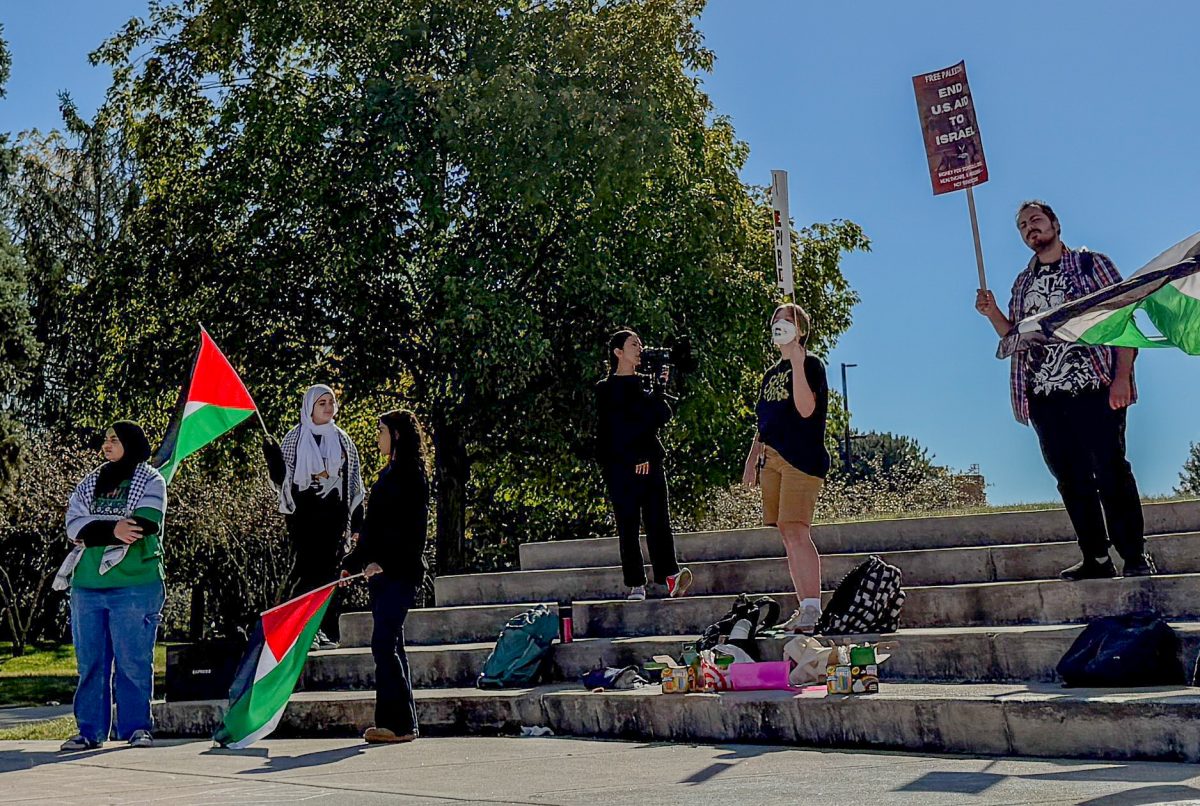 Student protesters hold Palestinian flags and signs during the rally held on Monday at MLK Commons. Students for Justice in Palestine hosted the event in honor of the one year anniversary of the conflict in Gaza. (Ryan Day | Northern Star)