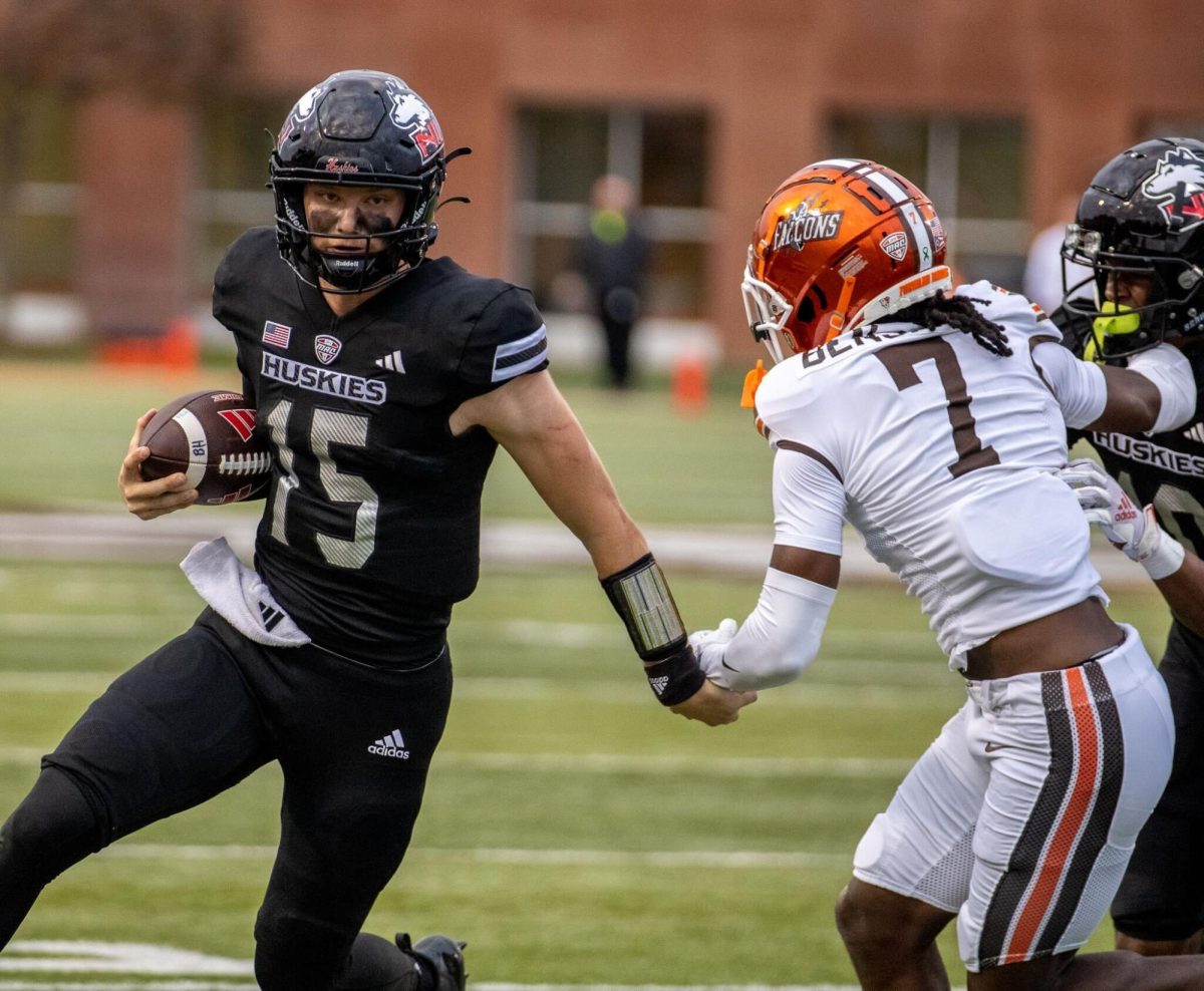 NIU redshirt freshman quarterback Josh Holst (15) rushes past Bowling Green State University senior cornerback Jacorey Benjamin (7) en route to the end zone for a 22-yard touchdown in the fourth quarter of NIU’s 17-7 upset of Bowling Green at Doyt L. Perry Stadium in Bowling Green, Ohio. Holst’s rushing touchdown was the first of his collegiate career. (Tim Dodge | Northern Star)