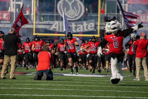  The Huskies run on the field pregame with Victor E. Huskie on Saturday for the 117th Homecoming game against the University of Toledo. The attendance for the 117th Homecoming game was 18,350. (Tim Dodge | Northern Star)