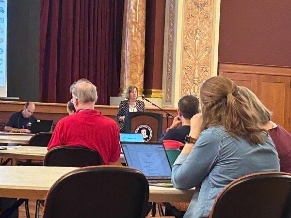 Laurie Elish-Piper, executive vice president and provost, stands behind a podium and speaks to the crowd at the Faculty Senate meeting Wednesday. Elish-Piper along with George Middlemist, chief financial officer, gave an update to members of Faculty Senate about NIU’s budget and deficit. (Emily Beebe | Northern Star)