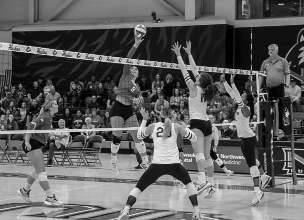 NIU freshman middle blocker Rylea Alvin (8) reaches up to hit the ball over the net. Alvin led the Huskies with four blocks and was followed by Hayes, Atiemo and Güvener with three blocks each. (Marco Alvarez | Northern Star) 