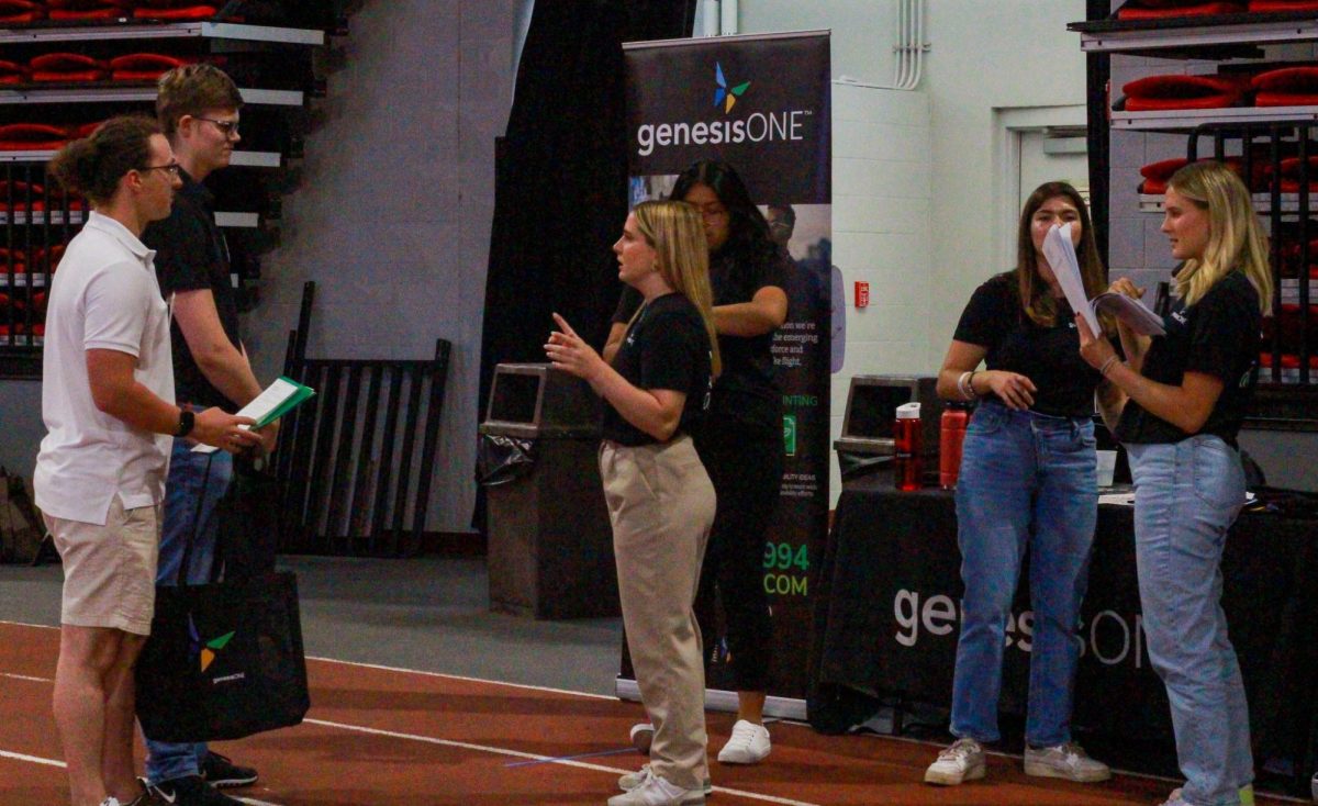 An employer from Genesis One talks to students at the All-Majors Internship and Job Fair held Wednesday in the Convocation Center. Free items such as water bottles, stress balls and snacks were given away at the Job Fair. (Ro Hong | Northern Star)