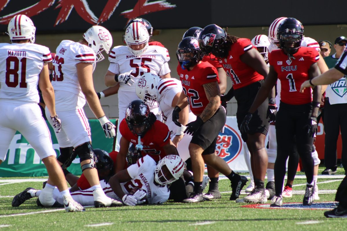 Multiple NIU players surround University of Massachusetts freshman running back Da'Marion Alberic after he was tackled by senior linebacker Jaden Dolphin short of the line of scrimmage. NIU defeated UMass 34-20 at Huskie Stadium on Saturday. (Marco Alvarez | Northern Star) 