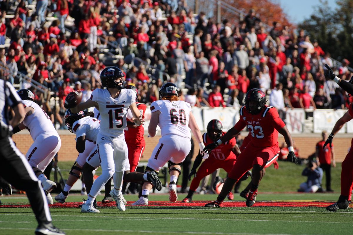 Redshirt freshman quarterback Josh Holst (15) winds back for a pass in the first half off NIU's Saturday matchup against Ball State University at Scheumann Stadium in Muncie, Indiana. Holst finished the first half with 64 passing yards, 1 interception and 1 fumble. (Tim Dodge | Northern Star)