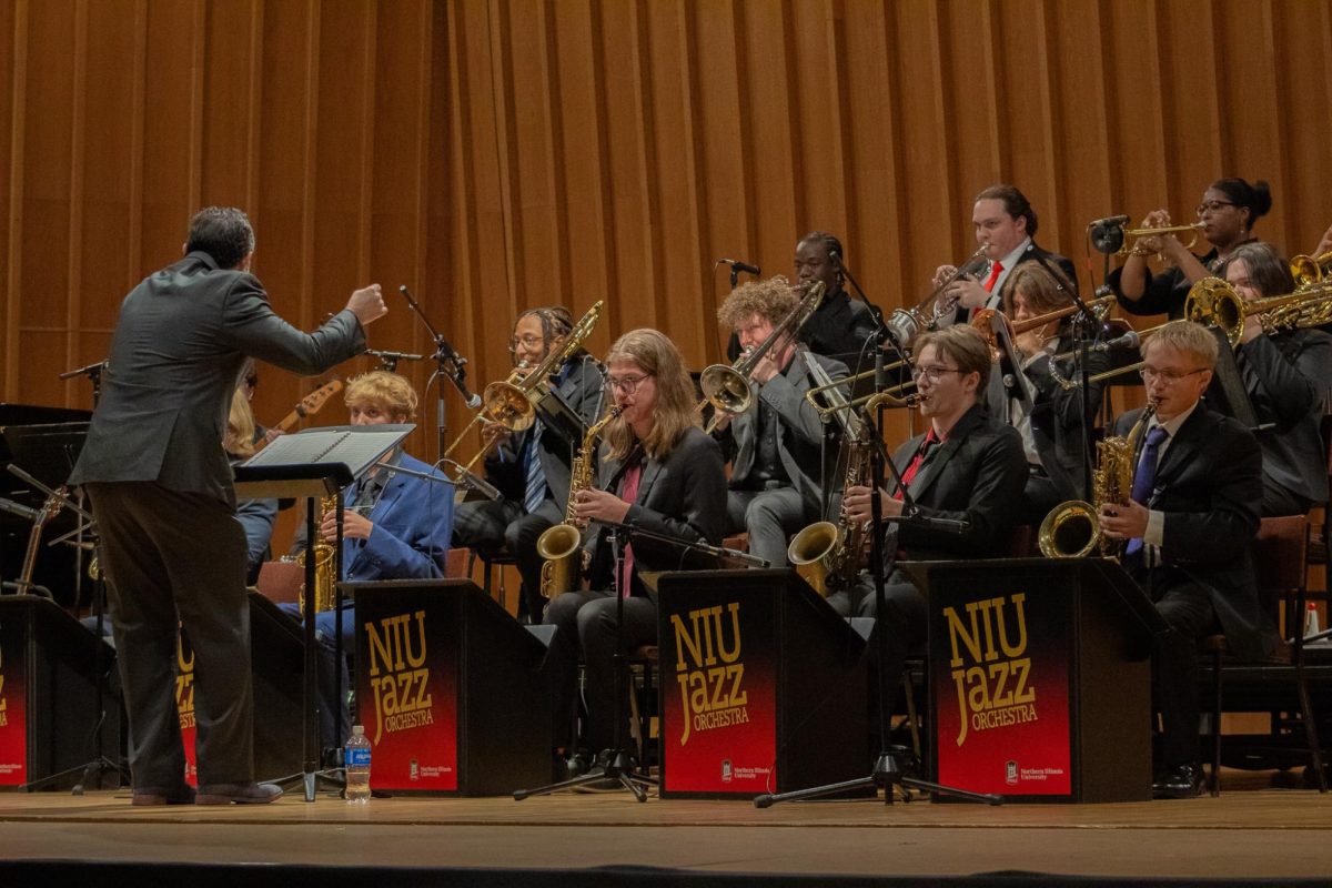 Rodrigo Villanueva, Professor of Jazz Studies, leans lower as the NIU Jazz Ensemble’s volume decreases during Wednesday’s performance. More jazz can be found at The Jazz Combofest at Fatty’s at 8 p.m Monday.  (Totus Tuus Keely | Northern Star)
