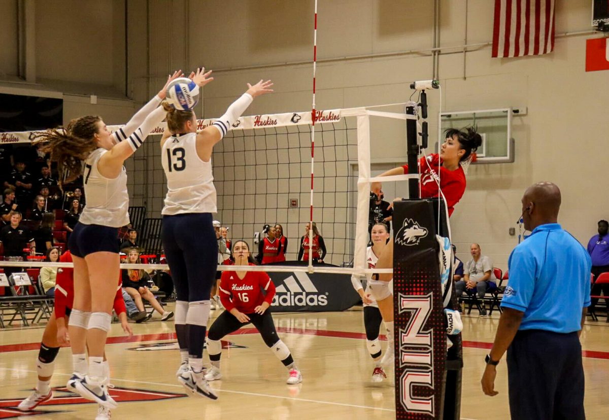 NIU junior outside hitter Nazli Güvener (17) makes contact with the University of Akron's freshman outside hitter Delaney Gash (13) following a spike on Friday at Victor E. Court in DeKalb. Güvener led the Huskies in kills with 18. (Marco Alvarez | Northern Star)