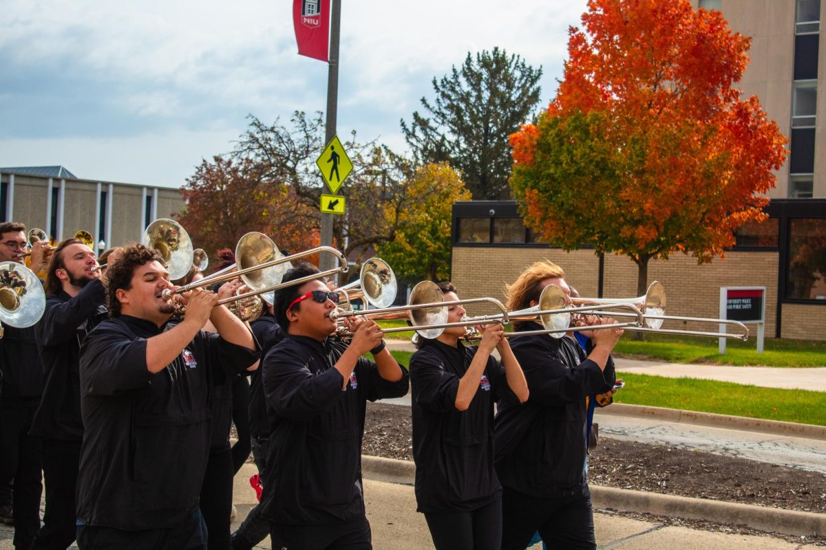 The Huskie Marching Band performs the Huskie Fight Song as they march past the University Police and Public Safety building on Lucinda Avenue. The Marching Band led the voter march to the Holmes Student Center performing their usual marching set. (Totus Tuus Keely | Northern Star)