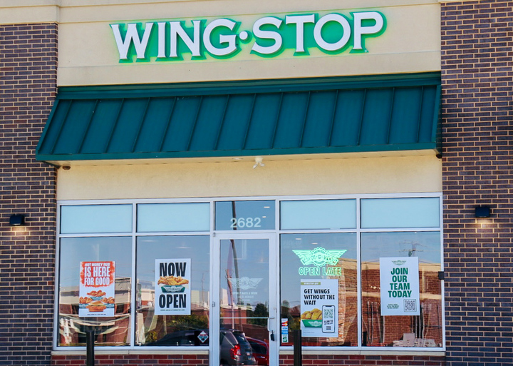 The front of a local Wingstop plastered with invitations to try their wings. Which Wingstop flavor is the best? (Marco Alvarez | Northern Star)