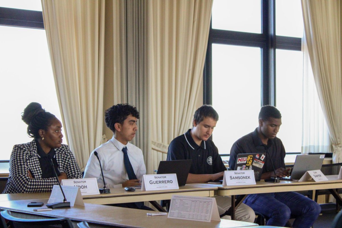 Senators Onyenum Udoh (from left), Eddie Guerrero, Paul Samsonek and Clerk Cameron Sawyer sit at a table during the SGA meeting Friday. In a vote of 9-0-2, SGA passed Bill SB56008 which allows senators to speak to the press. (Ethan Rodriguez | Northern Star)