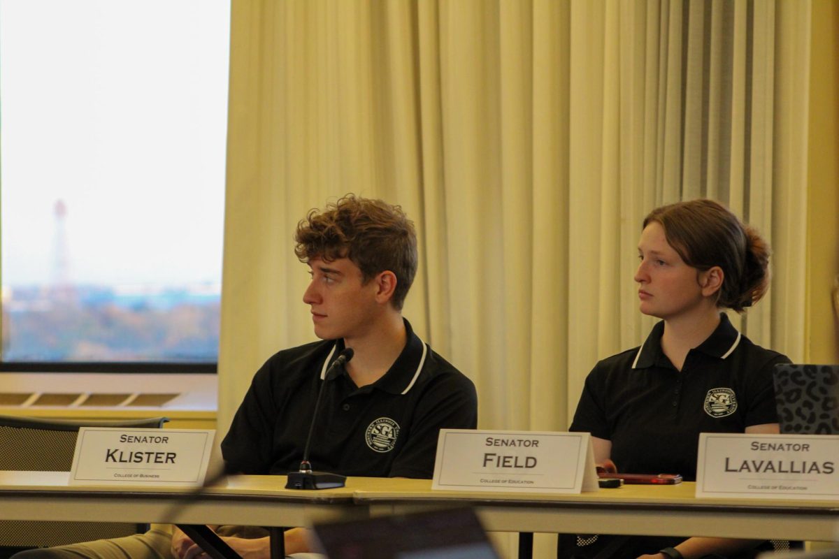 Senators Kevin Klister and Caitlin Field sit at a table and listen to Speaker Manny Corpuz talk at the SGA meeting Friday. SGA passed resolution SR56014, which confirmed that senators will receive a stipend amount of $250 for the spring semester. (Ethan Rodriguez | Northern Star)