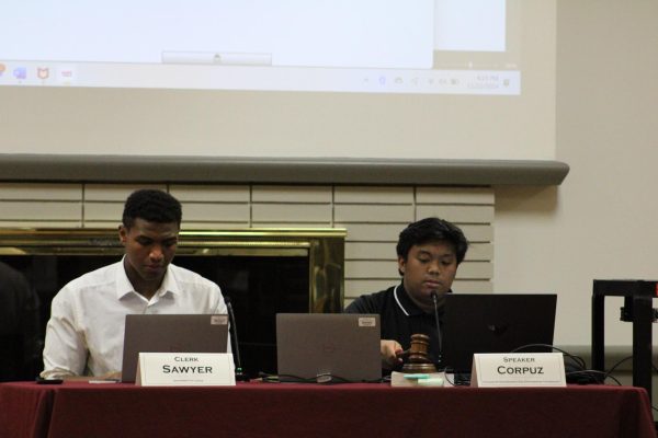 Speaker Manny Corpuz and Clerk Cameron Sawyer sit at a table while Corpuz bangs the gavel on the table during the Student Government Association meeting Friday. Senator Matt Robinson was reinstated as senator at the meeting on Friday. (Ethan Rodriguez | Northern Star)