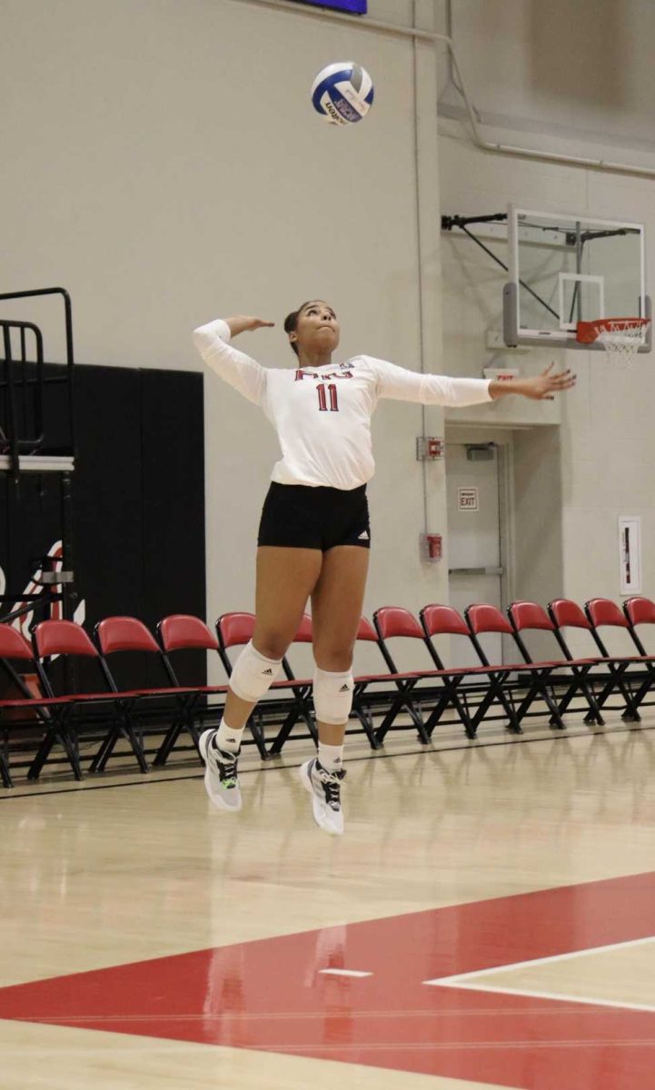 Senior middle blocker Charli Atiemo leaps and winds up for a serve on Nov. 8 at Victor E. Court. NIU volleyball lost its season finale in four sets to Miami University on Saturday. (Marco Alvarez | Northern Star)