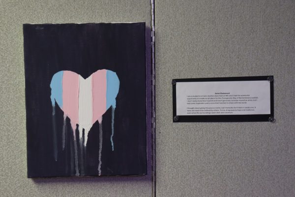 A painting hangs inside the Transgender Day of Remembrance exhibit in the Holmes Student Center. This piece from a trans student represents hope and resilience. (Marco Alvarez | Northern Star) 