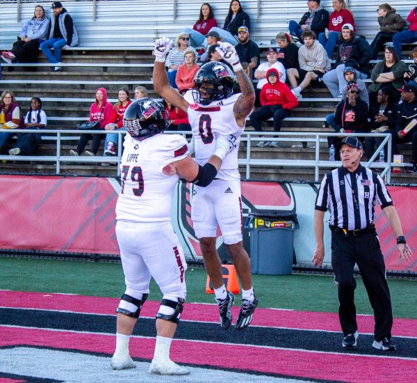 NIU redshirt senior offensive lineman J.J Lippe (79) lifts redshirt sophomore wide receiver Cam Thompson (0) after celebrating a touchdown late in the second quarter against Ball State University on Oct. 26. The Huskies host the University of Akron  Wednesday for their second midweek MACtion game. (Tim Dodge | Northern Star)