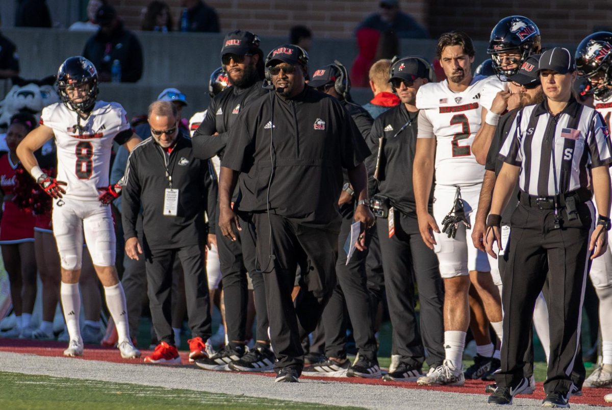 NIU football head coach Thomas Hammock, coaching staff and players watch from the sidelines during the third quarter. NIU’s next home game is on Wednesday against the University of Akron. (Tim Dodge | Northern Star)