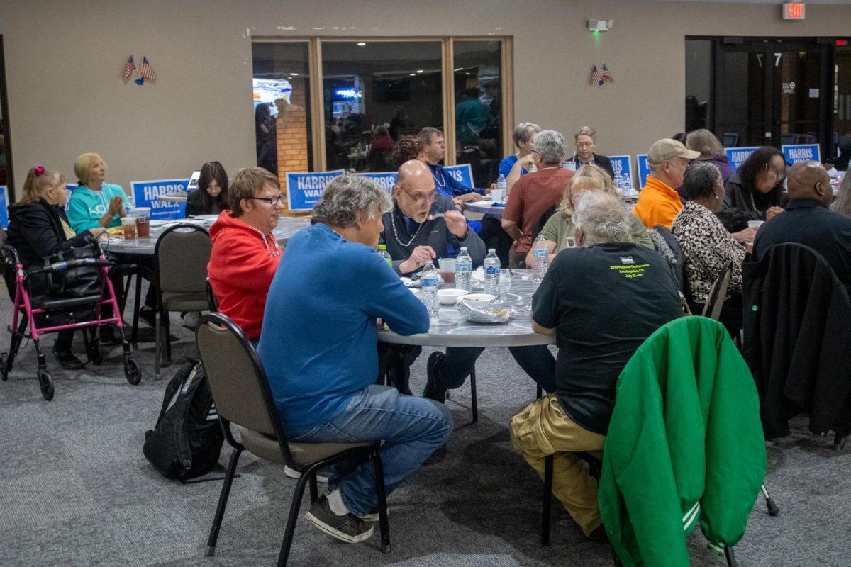 Party watchers sit and eat food inside at a Democrat Election Party at 1020 Sharon Drive. The majority of the people at the party were of a middle-aged demographic. (Tim Dodge | Northern Star)  
