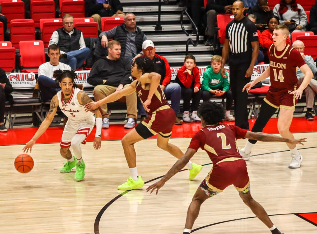 NIU sophomore guard Kailon Nicholls (5) resists defense from Elon University redshirt sophomore guard Andrew King during the second half of the Huskies' 75-48 loss to the Phoenix on Wednesday night inside the Convocation Center in DeKalb. The loss was the Huskies' first defeat at home of the 2024-25 campaign. (Marco Alvarez | Northern Star)