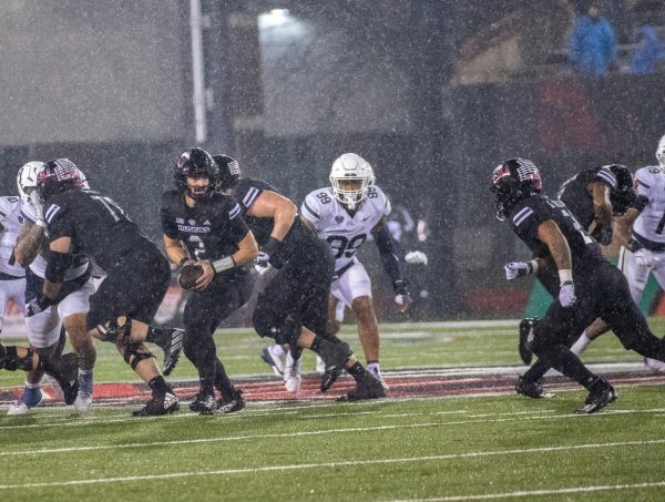 Redshirt junior quarterback Ethan Hampton (2) turns and prepares to hand the ball to redshirt senior running back Gavin Williams (21) on Wednesday at Huskie Stadium. NIU football will play the Miami University RedHawks on Tuesday, seeking to bring the Mallory Cup to NIU for the first time since it was created in 2018. (Tim Dodge | Northern Star)