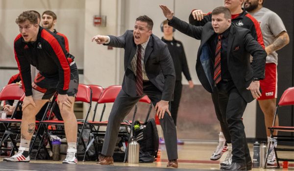 The NIU wrestling coaching staff encourages from the sidelines in the Huskies' meet against Southern Illinois University Edwardsville in February. The Huskies suffered their first loss Saturday against Northwestern University. (Tim Dodge | Northern Star)