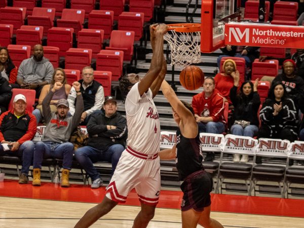 Senior forward Oluwasegun Durosinmi (4) dunks the ball over Holy Cross College Indiana junior Asher Puhalski (22). Durosinmi had 8 points, 5 rebounds and 3 blocks. (Tim Dodge | Northern Star) 