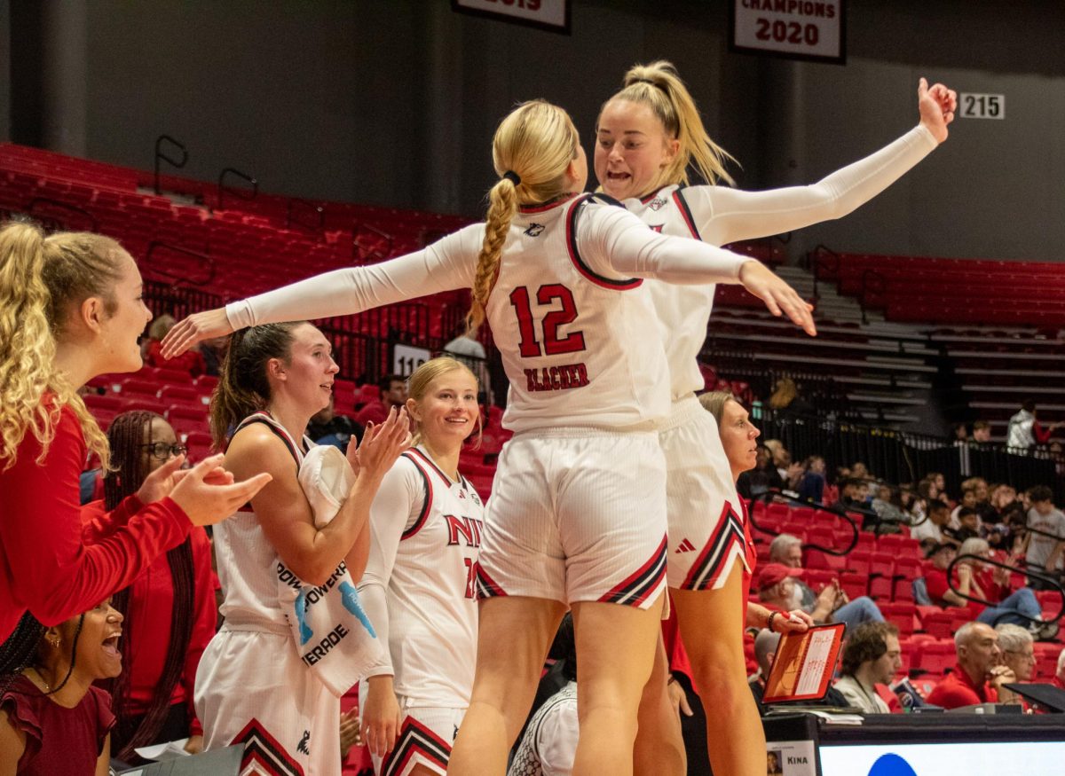 Sophomore guard Shannon Blacher (12) and junior forward Reagan Barkema (23) chest bump in celebration after Barkema's three-pointer tied the game at 55-55 against the University of Louisiana at Lafayette Ragin' Cajuns on Monday. The Huskies overcame the Ragin' Cajuns 57-55 in their home and season opener. (Katie Follmer | Northern Star)