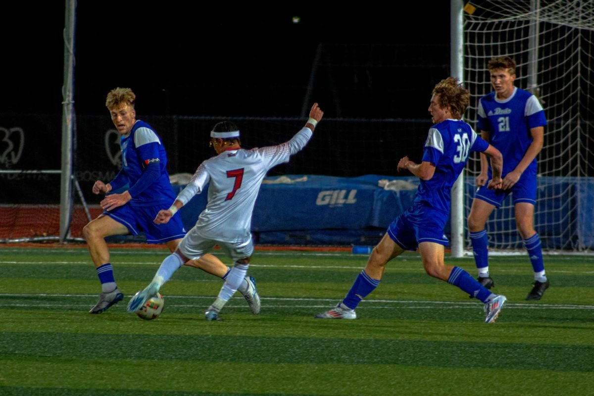 Senior forward Zachariah Thomas (7) shoots the ball between defenders on Friday at the NIU Soccer and Track & Field Complex. Thomas scored a goal in the 63rd minute on Wednesday as NIU men's soccer tied Bradley University in the season finale. (Northern Star File Photo)